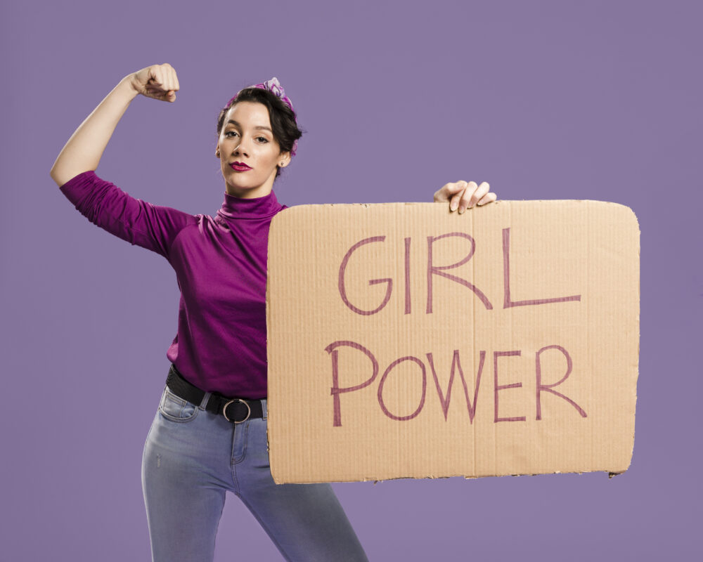 Mujer con cartel de Girl Power con fondo morado.