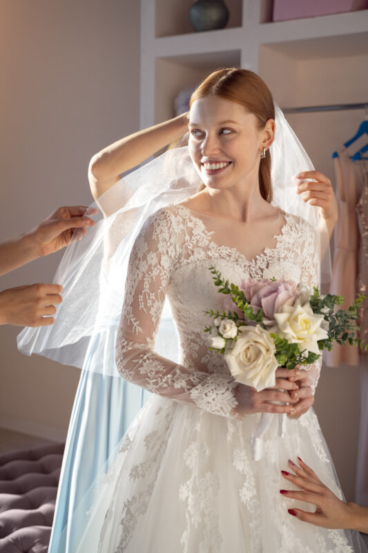 Mujer con vestido de novia y ramo de rosas.
