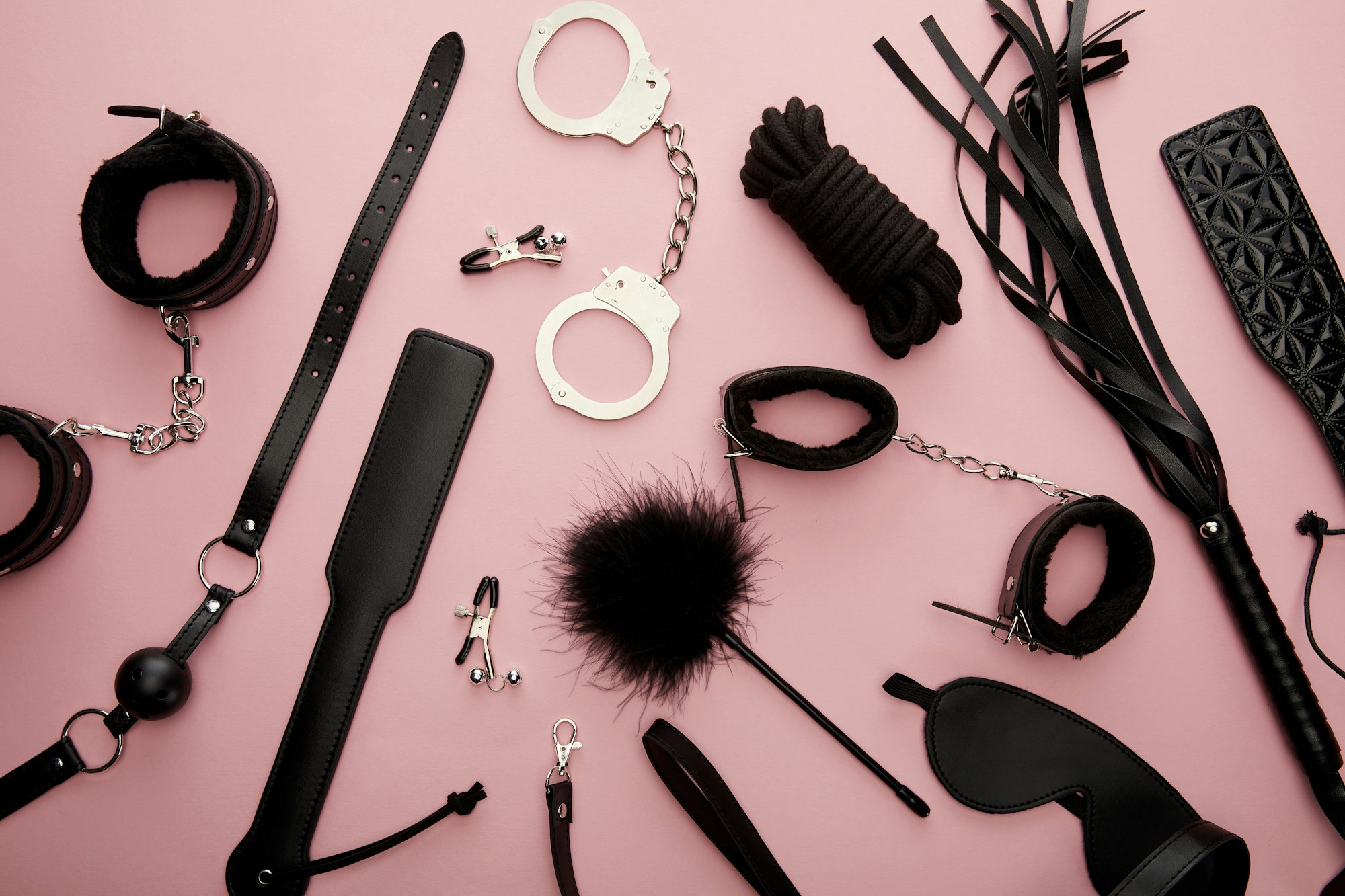 top view of black sex toys on pink background