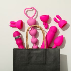 Sex toys spill out of a paper bag, top view